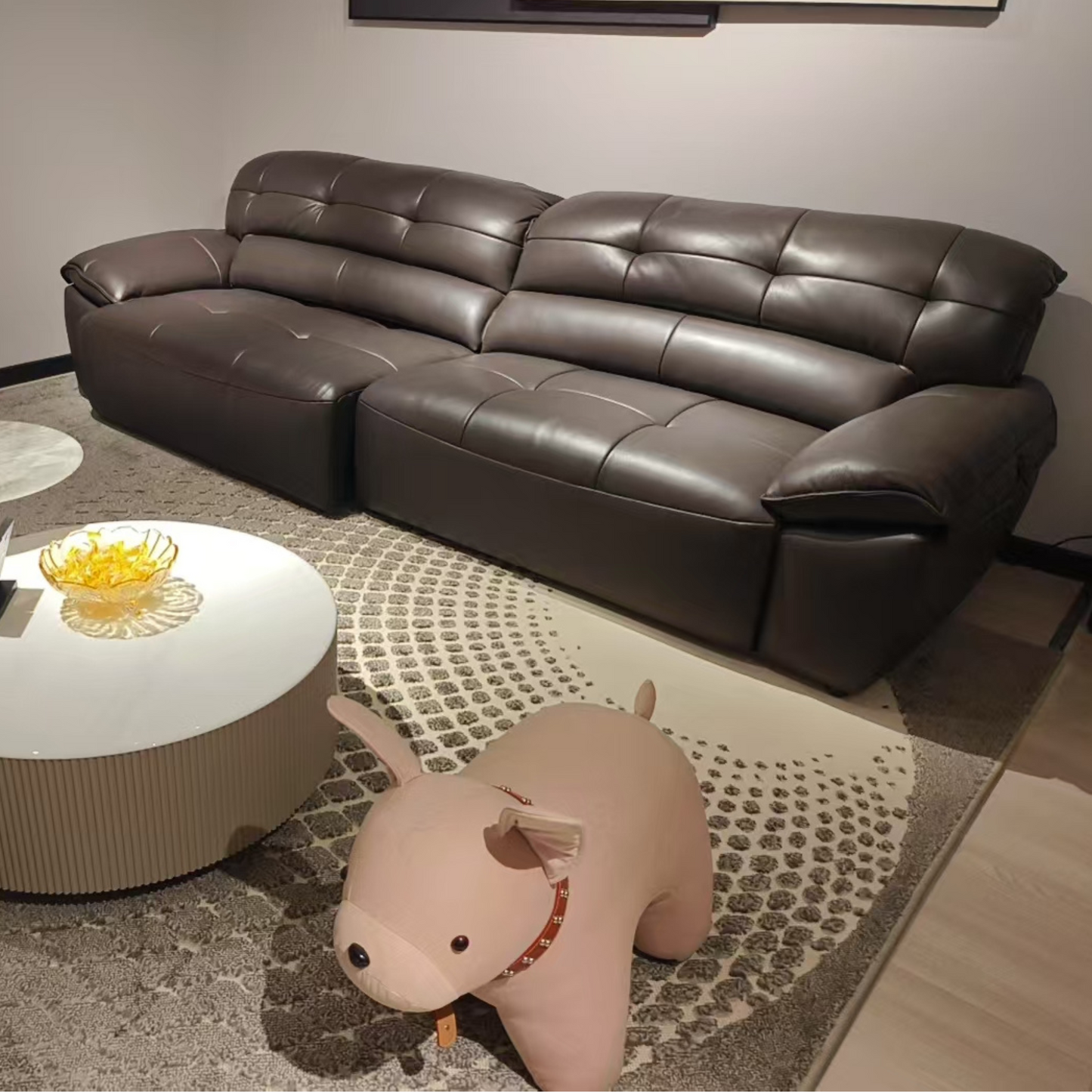 Brown leather sectional sofa in a living room setting with a coffee table and decorative items.