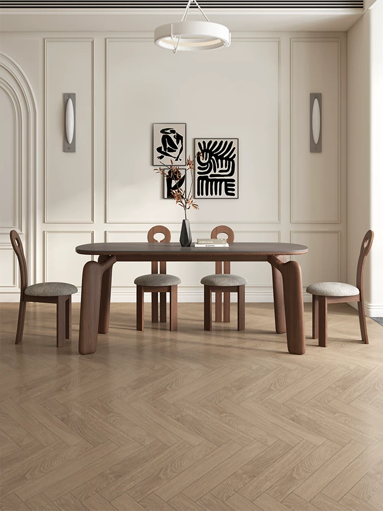 Dining room with a wooden table and chairs against a wall with abstract art.