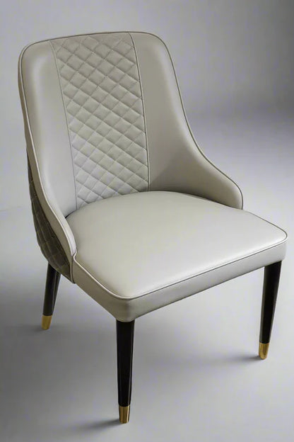Front view of Diamond Luxe PU leather chair with diamond-quilted stitching, integrated armrests, and wooden legs with brass tips