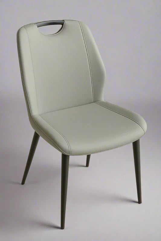 Front view of modern light grey PU leather dining chair with perforated finish and black metal legs with gold tips