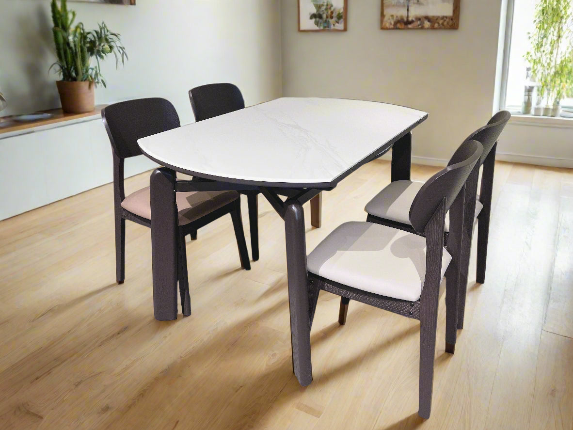 Dining table set with four chairs in a room with light-colored walls and carpet.