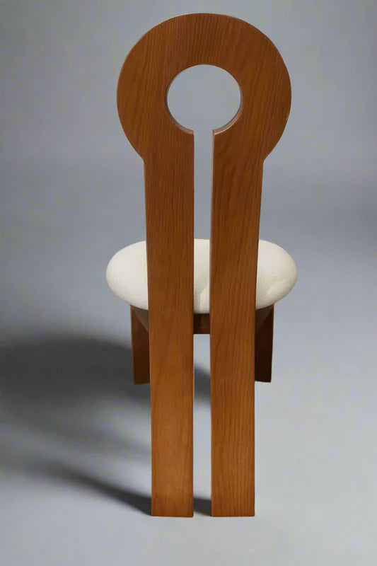 Side view of oak wood dining chair showcasing keyhole backrest design with extended rear legs and plush velvet upholstery