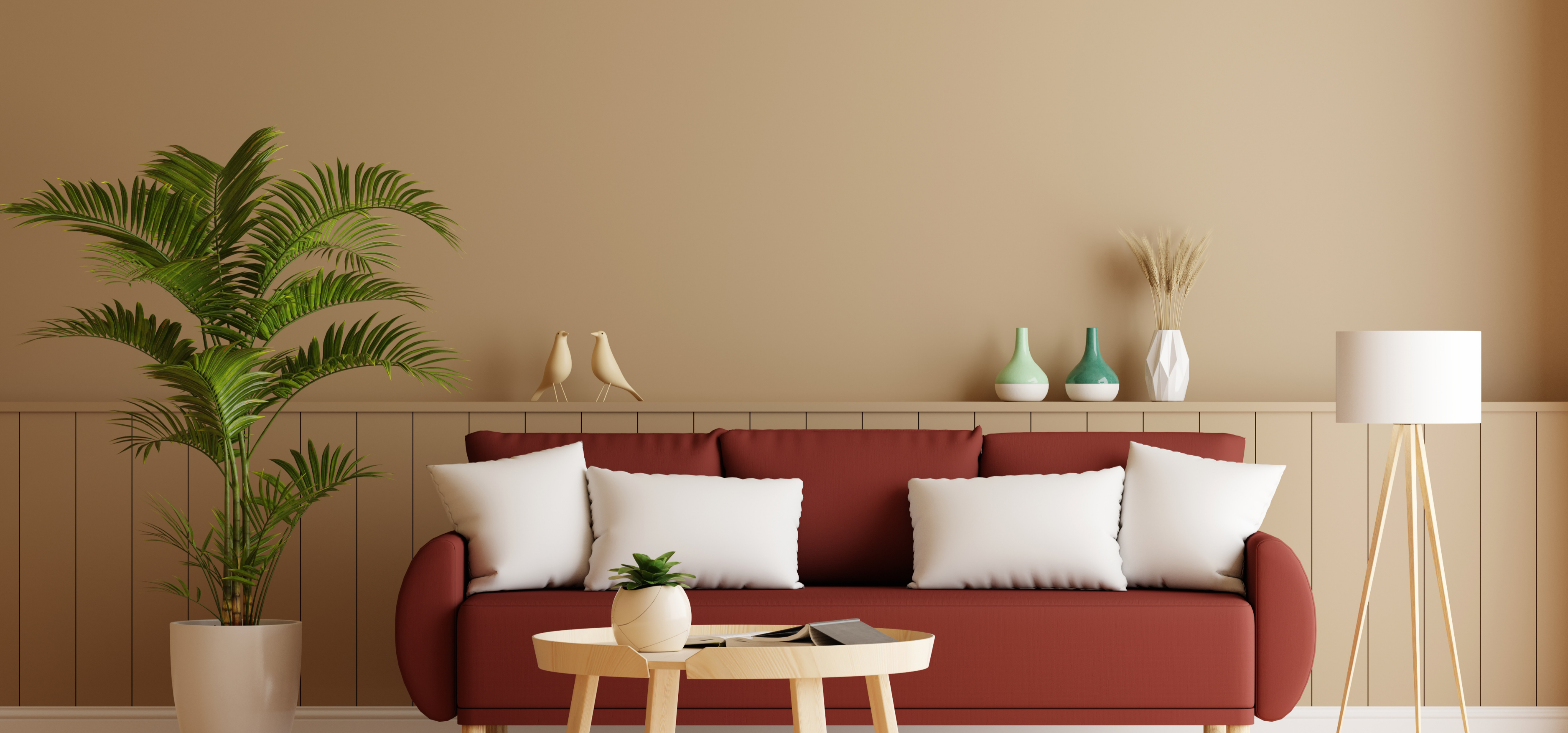 Red sofa with white cushions in a living room setting with a plant and small table.