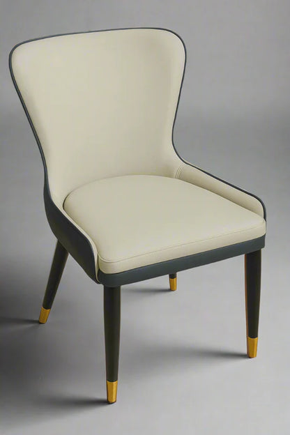 Front view of two-tone PU leather dining chair featuring cream upholstery, navy side panels, and gold-tipped black legs